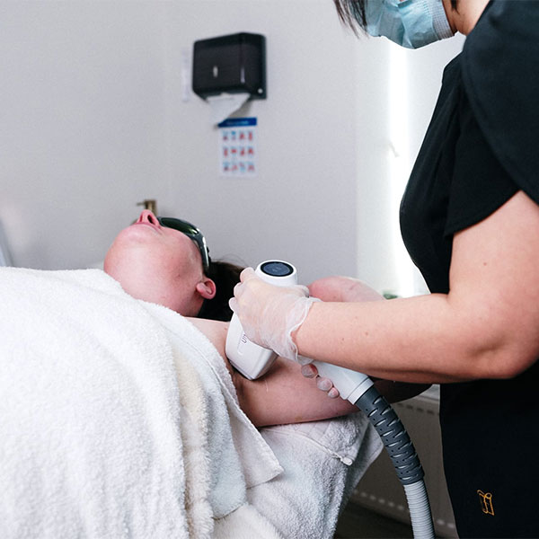 Woman receiving under arm laser hair removal at clinic in Ruthin, North Wales